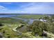This aerial view captures the serene beauty of the waterway, the lush marshland, and the neighborhood beyond at 185 Wappoo Rd, Charleston, SC 29407
