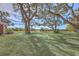 Spacious backyard with tire swing, mature trees, and serene water views in the distance at 185 Wappoo Rd, Charleston, SC 29407