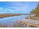 Picturesque dock view highlighting tranquil waters, marshlands, and clear blue skies at 185 Wappoo Rd, Charleston, SC 29407