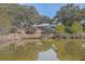 Picturesque view of home next to pond, featuring mature trees and serene water reflections at 185 Wappoo Rd, Charleston, SC 29407