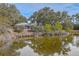Picturesque view of home next to pond, featuring mature trees and serene water reflections at 185 Wappoo Rd, Charleston, SC 29407