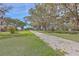 Inviting front yard view featuring a gravel driveway and majestic trees with Spanish moss at 185 Wappoo Rd, Charleston, SC 29407