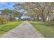 Charming home with a gravel driveway lined by mature trees draped in Spanish moss at 185 Wappoo Rd, Charleston, SC 29407
