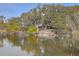 Charming pond view with trees reflecting on the water and a glimpse of the house at 185 Wappoo Rd, Charleston, SC 29407