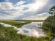 Beautiful waterfront view with calm waters, lush marsh grass, and a private dock at 185 Wappoo Rd, Charleston, SC 29407
