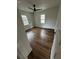 Bright bedroom featuring stylish wood-look flooring, modern ceiling fan, and white trim around the two windows at 201 Hayden St St, Walterboro, SC 29488