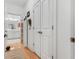 Hallway view of the bathroom featuring white painted walls, wood floors, and white cabinets at 2244 Ashley Crossing Dr # 426, Charleston, SC 29414