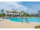 Community pool with lift, clubhouse, lounge chairs and mature palm trees on a sunny day at 2280 Minfarm Way # 529, Mount Pleasant, SC 29466
