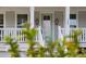 Close-up view of the front porch with a green door, decorative lanterns, and charming details at 2280 Minfarm Way # 529, Mount Pleasant, SC 29466