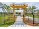 Gazebo with a wood pergola entryway, black metal fence, and sidewalk leading to the structure at 2280 Minfarm Way # 529, Mount Pleasant, SC 29466