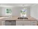 Bright kitchen island with stainless steel dishwasher and hardwood flooring at 2838 Otranto Rd, North Charleston, SC 29406