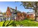 A well-maintained, green backyard showcasing the brick home exterior and mature shade tree at 285 Grove St, Charleston, SC 29403