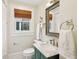 Charming bathroom with marble countertop vanity, framed mirror, window with shade, and modern toilet at 285 Grove St, Charleston, SC 29403