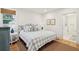 Bedroom with blue and white patterned bed, hardwood floors, a window, and an ensuite bathroom at 285 Grove St, Charleston, SC 29403