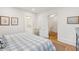 Bedroom featuring light walls, hardwood floors, and doorways leading to a bathroom and walk-in closet at 285 Grove St, Charleston, SC 29403