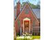 Charming red brick home with a gabled roof, symmetrical windows, and a warm wooden front door at 285 Grove St, Charleston, SC 29403