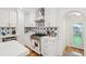 Bright white kitchen showing a stainless steel range and oven plus decorative blue tile backsplash at 285 Grove St, Charleston, SC 29403