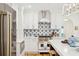 Charming white kitchen showcasing stainless steel appliances and a star-patterned tile backsplash at 285 Grove St, Charleston, SC 29403