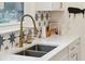 Close up of kitchen sink featuring brass faucet, white countertops, and patterned backsplash tile at 285 Grove St, Charleston, SC 29403