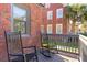 Relaxing porch features rocking chairs, brick accents, and views of the lush backyard and neighborhood at 285 Grove St, Charleston, SC 29403