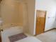 Clean bathroom features a bathtub with shower, a door, and white tile floors at 315 King Charles Cir, Summerville, SC 29485
