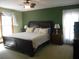 Primary bedroom with green walls, ceiling fan and a large bed with floral patterned quilt at 315 King Charles Cir, Summerville, SC 29485
