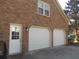 Two-car garage exterior with white doors, brick facade, and a convenient side entrance at 315 King Charles Cir, Summerville, SC 29485