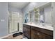 Well-lit bathroom with double vanity, modern mirrors and glass-enclosed shower at 324 Spruce Ivy St, Moncks Corner, SC 29461