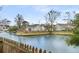Scenic backyard with a tranquil lake view, surrounded by a wooden fence and mature trees at 366 Clayton Dr, Charleston, SC 29414