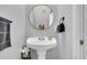 Stylish powder room featuring a pedestal sink, round mirror, and modern fixtures at 366 Clayton Dr, Charleston, SC 29414