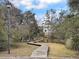 Charming wooden walkway leading to a waterfront home, surrounded by lush greenery at 366 Clayton Dr, Charleston, SC 29414