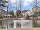 Scenic pond view featuring a fountain and surrounding homes with backyard play set, fences, and mature trees at 366 Clayton Dr, Charleston, SC 29414