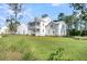 Two-story home featuring a manicured lawn, mature trees, and an adjacent side yard with play set at 3864 Summerton St, Mount Pleasant, SC 29466