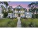 Beautiful two-story white home featuring a charming front porch and lush greenery, perfect for outdoor living at 3864 Summerton St, Mount Pleasant, SC 29466