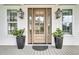 Elegant front door with glass panes flanked by classic lanterns, adding a touch of sophistication at 3864 Summerton St, Mount Pleasant, SC 29466