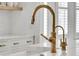Close up of the kitchen faucet with a gold finish complemented by white countertops at 3864 Summerton St, Mount Pleasant, SC 29466