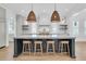A kitchen island with marble countertops and stylish stools and lighting at 3864 Summerton St, Mount Pleasant, SC 29466