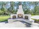 A charming white brick outdoor fireplace with a seating area and wood storage is perfect for backyard gatherings at 3864 Summerton St, Mount Pleasant, SC 29466