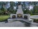 Outdoor fireplace and entertainment area with fireplace, benches, and wood storage at 3864 Summerton St, Mount Pleasant, SC 29466