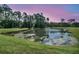 A pond surrounded by lush greenery and trees with reflections of the sky and trees in the water at 3864 Summerton St, Mount Pleasant, SC 29466
