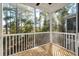 Screened-in porch with wood flooring, white railings, and view of the surrounding trees at 406 Katies Scenic Ct, Charleston, SC 29492