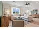 Bright living room showcasing a large neutral sectional, ceiling fan, wood floors and view to the outdoors at 414 Duskywing Dr, Goose Creek, SC 29445