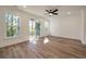 Sun-lit living room with wood-look floors and doors to a balcony with wooded views at 414 Katies Scenic Ct, Charleston, SC 29492