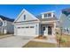 Charming home with a white garage door, blue siding, and a well-maintained front yard on a clear day at 417 Grove End Rd, Moncks Corner, SC 29461