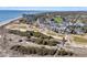Expansive aerial view showcasing a coastal community with beachfront condos, homes, a golf course, and ocean access at 45 Ocean Point Dr, Isle of Palms, SC 29451