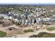 Stunning aerial view of coastal homes nestled along a golf course and a serene pond, offering picturesque waterfront living at 45 Ocean Point Dr, Isle of Palms, SC 29451