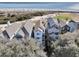 Stunning aerial view of coastal homes nestled among trees, with the ocean and a golf course in the backdrop at 45 Ocean Point Dr, Isle of Palms, SC 29451
