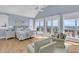 Spacious bedroom with water view, light hardwood floors, and sitting area at 45 Ocean Point Dr, Isle of Palms, SC 29451