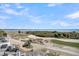 Expansive golf course view with ocean backdrop from a deck overlooking lush greenery under a sunny sky at 45 Ocean Point Dr, Isle of Palms, SC 29451