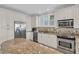 Spacious kitchen features white cabinetry, stainless steel appliances, and granite countertops at 45 Ocean Point Dr, Isle of Palms, SC 29451